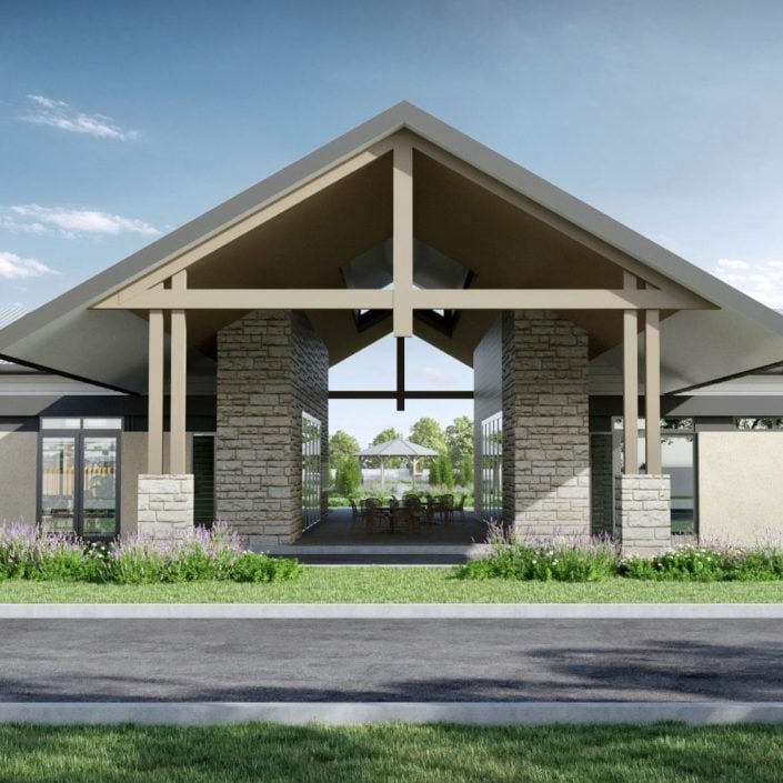 A modern building with a pitched roof, stone pillars, and large open entrance is surrounded by grass, plants, and trees under a partly cloudy sky—a perfect setting for Lincoln Lifestyle over 50s living in Mudgee.