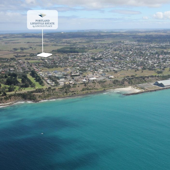 Aerial view of a coastal town with turquoise water, sandy shoreline, and green fields. A label points to Portland Lifestyle Estate, 44 Henty Place—home of the upcoming Bowls Tournament. RSVP now to join the excitement near the coast.