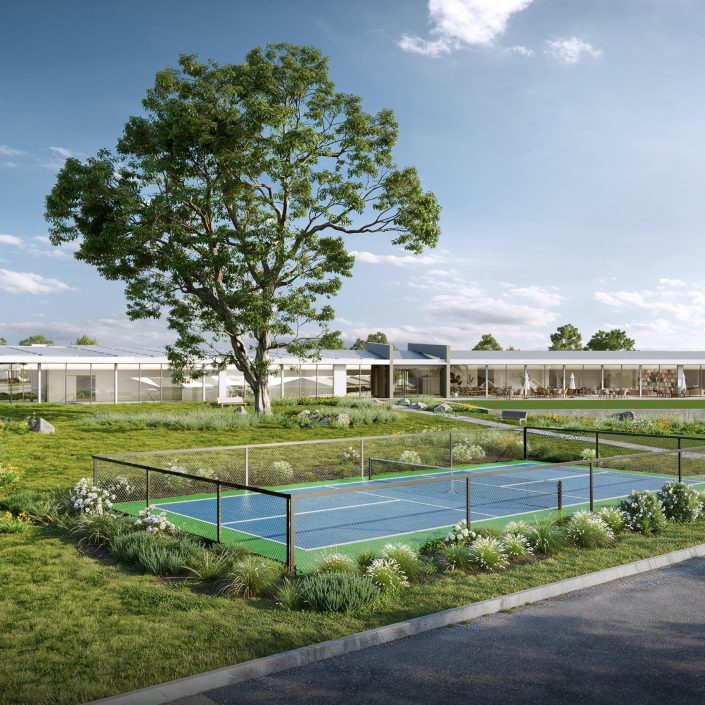 A modern building with large windows sits behind a fenced tennis court and lush green landscaping under a blue sky at Eagle Point, with a large tree and parked cars nearby—perfect for enjoying the Lincoln Lifestyle.