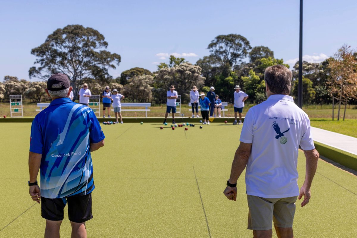 Two men playing in a bowls tournament