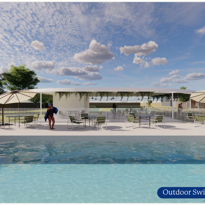 A person stands by a swimming pool with clear blue water in a Land Lease Community, surrounded by loungers and umbrellas. In the background, green grass, trees, and a covered patio create a relaxing setting for Over 50s.